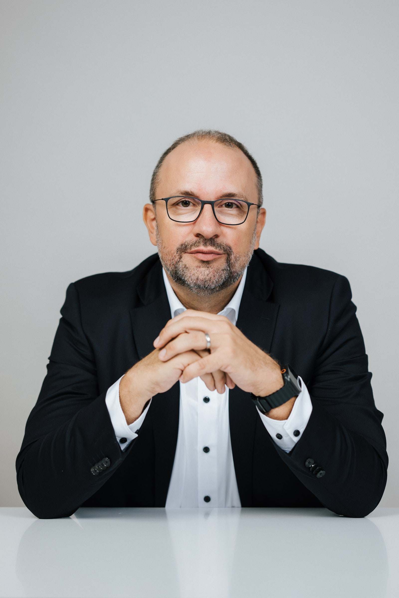 Matthias Biskupek am Besprechungstisch, die Hände gefaltet